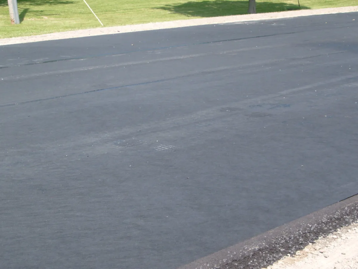 Freshly installed paving fabric across a resurfaced roadway