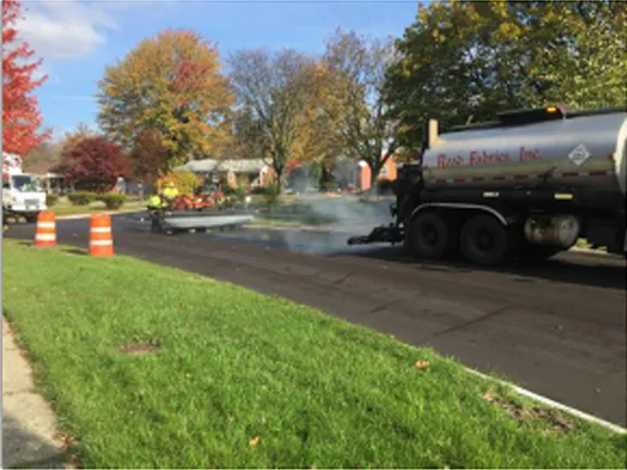 Road Fabrics tanker truck applying sealant on a residential street