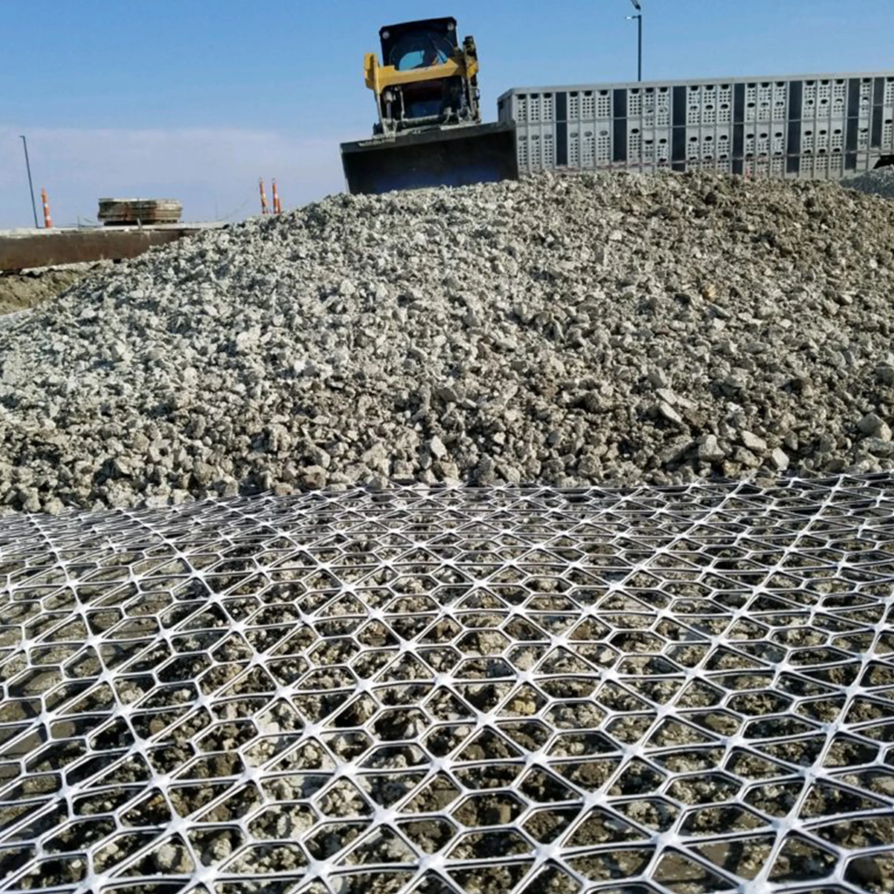 Tensar geogrid being covered with aggregate during subgrade stabilization
